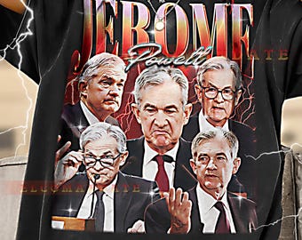 May include: Black t-shirt featuring a graphic of several men in suits, with the name "Jerome Powell" in a stylized font. The design includes lightning bolt accents and the word "ELCOMA" and "ATE" on the sides.