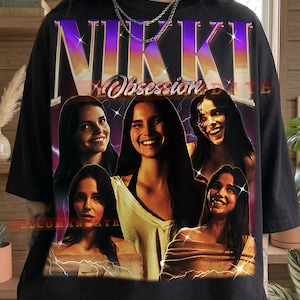 May include: Black t-shirt with a graphic design featuring the word "NIKKI" in purple and gold lettering, with the word "Obsession" below. The design includes multiple images of a woman. The word "Black" is printed at the bottom.