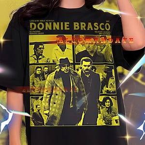 Op de afbeelding: Zwart unisex T-shirt met een geel en zwart grafisch ontwerp van de film "Donnie Brasco". Het ontwerp bevat de titel van de film, namen van de cast en een collage van afbeeldingen. Het shirt is maat 2XL.