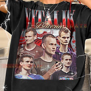May include: Black t-shirt featuring a collage of images and the text "VITALIK BUTERIN UPDATE" in red and white. The design includes multiple portraits of a man in various poses.