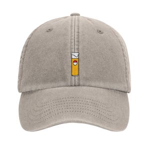 May include: A grey baseball cap with a yellow and red beer can graphic embroidered on the front.