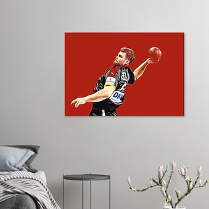 Puede incluir: Impresión artística digital de un jugador de balonmano en acción sobre un fondo rojo. El jugador, con uniforme blanco y negro con "DK" visible, está en pleno lanzamiento con un balón de balonmano. Estilo gráfico audaz.