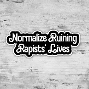 以下が含まれることがあります： 「Normalize Ruining Rapists' Lives」というテキストが太字でスタイリッシュな丸みを帯びた白フォントで書かれた、白い縁取りの黒いステッカー。テキストは2行に配置されており、1行目に「Normalize Ruining」、2行目に「Rapists' Lives」と記されています。
