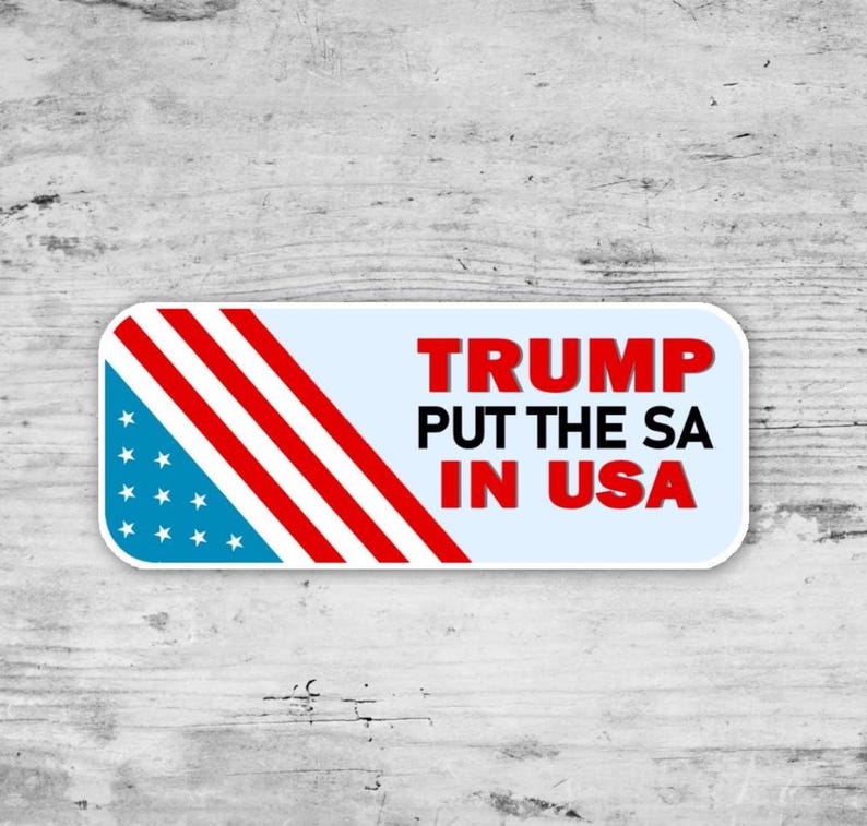 May include: A rectangular sticker with a light blue background and rounded corners. The left side features a design of the American flag. The text "TRUMP PUT THE SA IN USA" is in red and black.