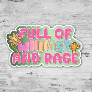 May include: A sticker with the text "FULL OF WHIMSY AND RAGE" in pink, blue, yellow, and orange bubble letters. The sticker has a green background and features a flower and a mushroom.
