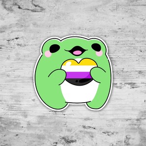 May include: A green cartoon frog holding a heart-shaped symbol with yellow, purple, and black stripes. The frog is smiling and has pink cheeks.