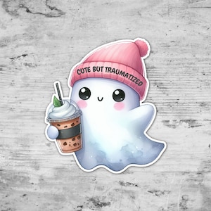 May include: A cute cartoon ghost wearing a pink beanie with the text "Cute but Traumatized" and holding a iced coffee.