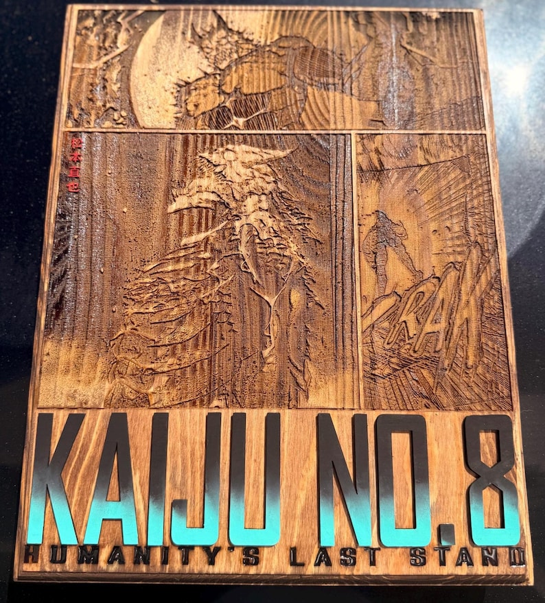 Puede incluir: Placa de madera con una ilustraci&oacute;n estilo c&oacute;mic. La obra de arte representa un gran monstruo y una figura en un paisaje rocoso. Las palabras "KAIJU NO. 8" est&aacute;n en letras negras grandes con un degradado turquesa, y "HUMANITY'S LAST STAND" debajo.