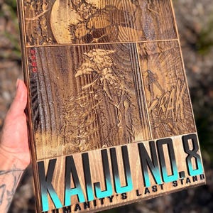 Puede incluir: Obra de arte de madera con una ilustraci&oacute;n tallada de un monstruo de la serie de manga Kaiju No. 8. La obra incluye el texto "KAIJU NO. 8" en negro y turquesa, y "HUMANITY'S LAST STAND".