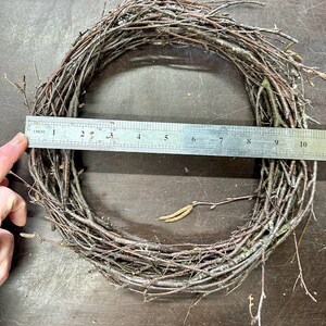 May include: A brown twig wreath measuring 10 inches in diameter. The wreath is made of natural twigs and is perfect for crafting.