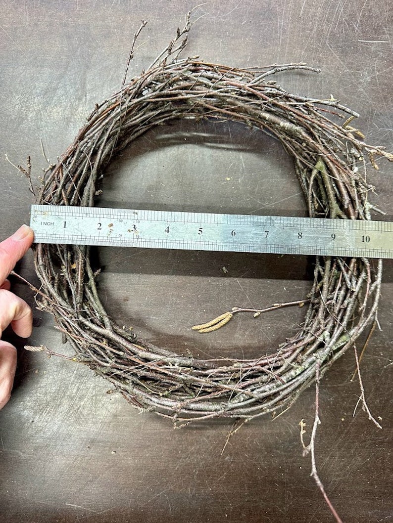 May include: A brown twig wreath measuring 10 inches in diameter. The wreath is made of natural twigs and is perfect for crafting.