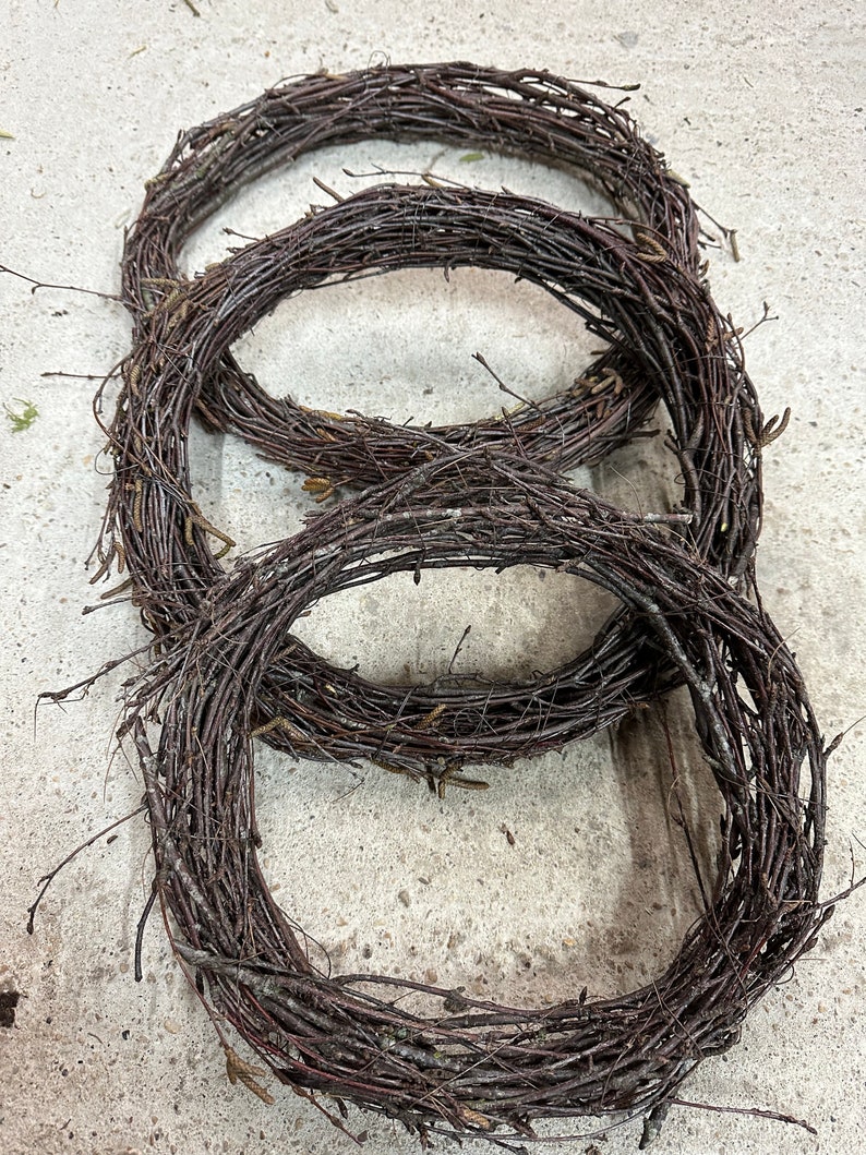 May include: Three brown twig wreaths of varying sizes, stacked on top of each other.