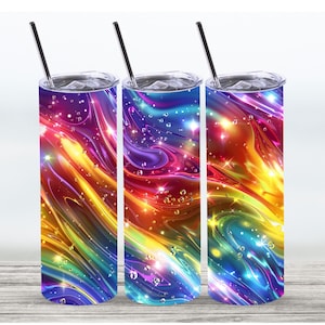 Könnte beinhalten: Drei Edelstahlbecher mit bunten abstrakten Designs. Die Designs zeigen wirbelnde Farben in Blau, Lila, Gelb, Orange und Rot mit einem glitzernden Effekt. Die Becher haben einen silbernen Deckel und einen Strohhalm.