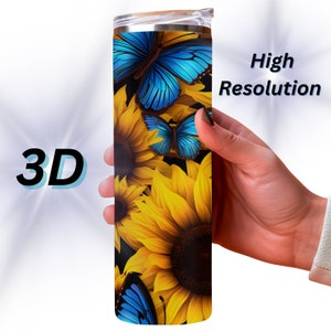 May include: A stainless steel tumbler with a black background and a design of yellow sunflowers and blue butterflies. The tumbler has a lid.