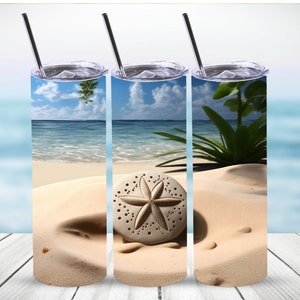 May include: Three stainless steel tumblers with a beach scene and a sand dollar on the sand. The tumblers have lids and straws.