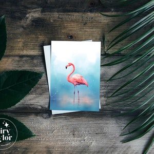 May include: A pink flamingo stands in a blue and white watercolor background. The flamingo is in a standing pose with its head tilted to the side. The background is a soft blue with white accents.