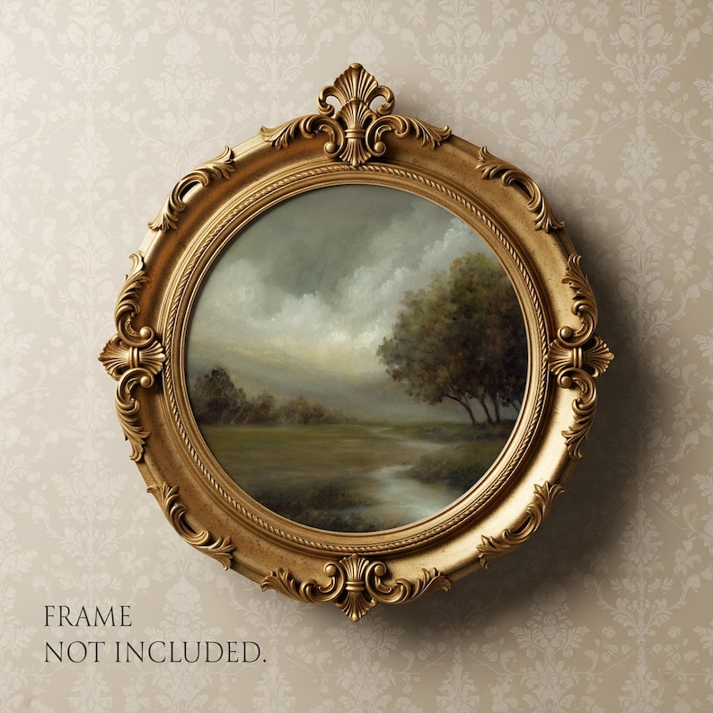May include: A round, ornate gold-colored frame featuring intricate scrollwork and decorative flourishes at the top and bottom. The frame contains a landscape painting of a field, a stream, and trees under a cloudy sky. Text reads: FRAME NOT INCLUDED.