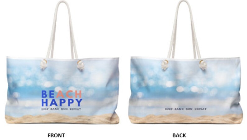 May include: A white canvas tote bag with a beach scene and the text "BEACH HAPPY" in blue and pink. The text "SURF SAND SUN REPEAT" is printed in blue on the front of the bag. The back of the bag has the text "SURF SAND SUN REPEAT" printed in blue.