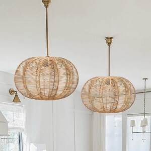 2 rattan pendant light in star shape are hung nicely over a farmhouse wooden kitchen island with white marble top and 4 kitchen stools, which is on the left of a big bright window with white curtain.