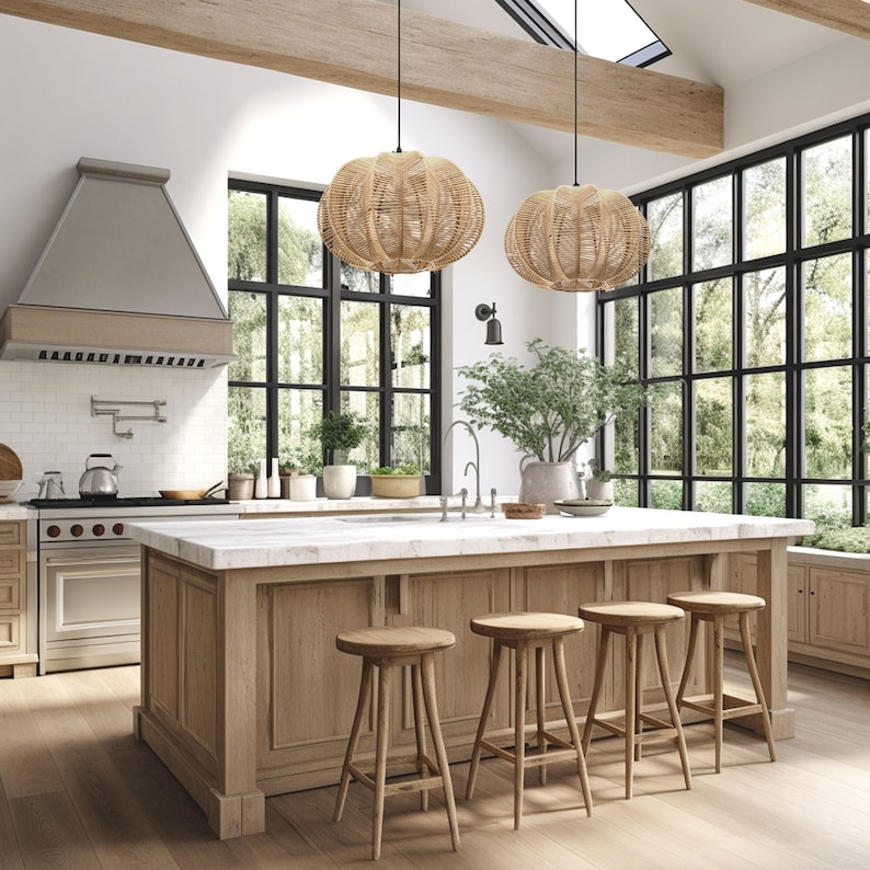 May include: A kitchen with a large island, wooden stools, and two woven pendant lights. The island has a marble countertop and a wooden base. Large windows offer a view of the outdoors. The kitchen features a stainless steel range hood and a white tile backsplash.