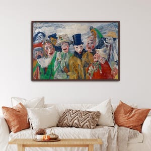 May include: A framed painting depicting a group of figures in colorful costumes and masks. The artwork features a variety of hats, coats, and facial expressions, with a cloudy sky background. The painting is displayed above a white couch with orange and white pillows.