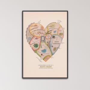May include: A framed print featuring a heart-shaped map titled Geographical Guide to a Man's Heart with obstacles and entrances clearly marked. The map is divided into colorful sections labeled Territory of the Big Operator and State of Solid Comfort.