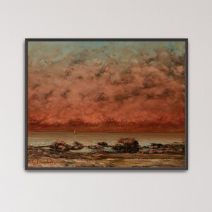 Op de afbeelding: Een olieverfschilderij in een zwarte lijst met een kustlandschap en een dramatische, dieprode en oranje zonsonderganglucht vol zware wolken boven een kalme zee. Donkere rotsen liggen verspreid over het strand op de voorgrond en de handtekening G. Courbet is zichtbaar in de linkerbenedenhoek.