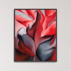 May include: A framed vertical wall art print featuring an abstract composition of overlapping, pointed leaf-like shapes in vibrant shades of red, deep crimson, and dark charcoal gray, set against a soft, pale pink and light gray background.