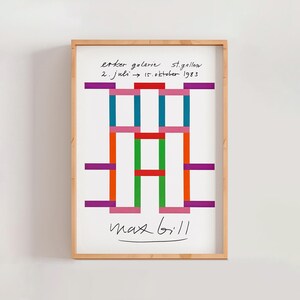 May include: A framed art print featuring a colorful geometric design with the text "erker galerie st. gallen 2. juli -> 15. oktober 1983" and the signature "max bill". The artwork uses red, purple, green, pink, and orange.