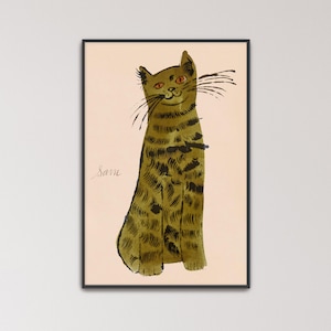 May include: A framed wall art print featuring an olive green tabby cat with dark brown stripes and orange eyes. The cat is depicted in a stylised ink wash technique on a light beige background. The name Sam is written in cursive script to the left.