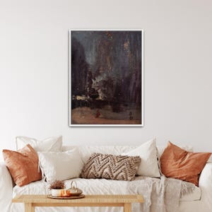 Pode incluir: Pintura abstrata emoldurada com uma paleta de cores escuras e melancólicas. A obra apresenta uma mistura de azuis profundos, castanhos e toques dourados, criando uma sensação de profundidade e mistério. A pintura é exibida acima de um sofá branco com almofadas laranja.