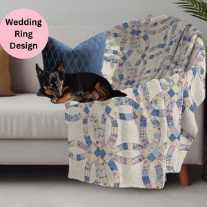 May include: A cream-colored throw blanket with a wedding ring design in blue, purple, and yellow patchwork is draped over a sofa. A small black and brown dog rests on the sofa. The text "Wedding Ring Design" is in a pink circle.