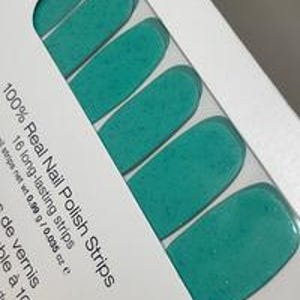 May include: A package of teal nail polish strips. The package contains 16 long-lasting strips of real nail polish. The text on the package reads "100% Real Nail Polish Strips". Each strip weighs 0.99g / 0.035 oz.