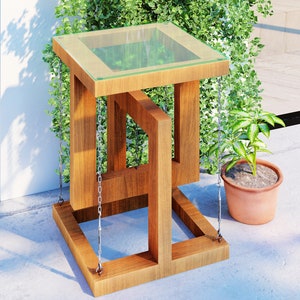 May include: A wooden side table with a glass top and a unique geometric design. The table is suspended by chains and has a natural wood finish.