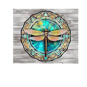 Puede incluir: Un diseño de libélula de vitral colorido con un esquema de colores azul, verde y amarillo. La libélula está rodeada por un patrón de mandala dorado.