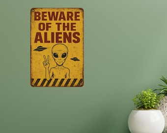 Señal divertida retro de OVNI con "Cuidado con los extraterrestres", amarilla desgastada