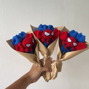 May include: Three crocheted bouquets of red and blue Spiderman characters wrapped in brown paper.