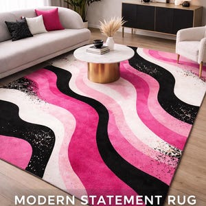 May include: A modern area rug with a bold, wavy design in shades of pink, black, and white. The rug features the text "MODERN STATEMENT RUG". The rug is placed on a hardwood floor.