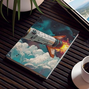 May include: A ceramic tile featuring a retro-style illustration of a rocket ship blasting off through clouds. A cup of coffee sits on a white saucer. A travel magazine is also on the dark wooden table.
