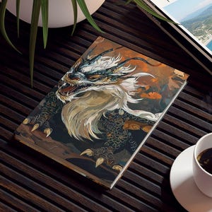 May include: A coffee table with a dragon art book, a travel magazine, a white coffee cup, and a potted plant. The dragon art book features a detailed illustration of a dragon's head.