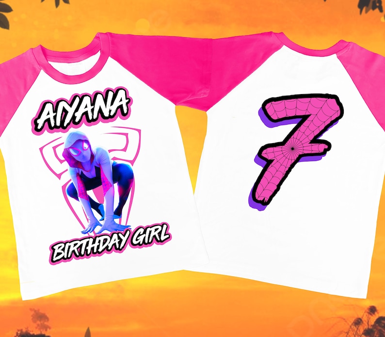 Puede incluir: Una camiseta de b&eacute;isbol blanca y rosa con un gr&aacute;fico de una ara&ntilde;a rosa y blanca en la parte delantera y el nombre "AIYANA BIRTHDAY GIRL" impreso debajo. La parte posterior de la camiseta tiene un n&uacute;mero rosa "7" con un dise&ntilde;o de telara&ntilde;a.