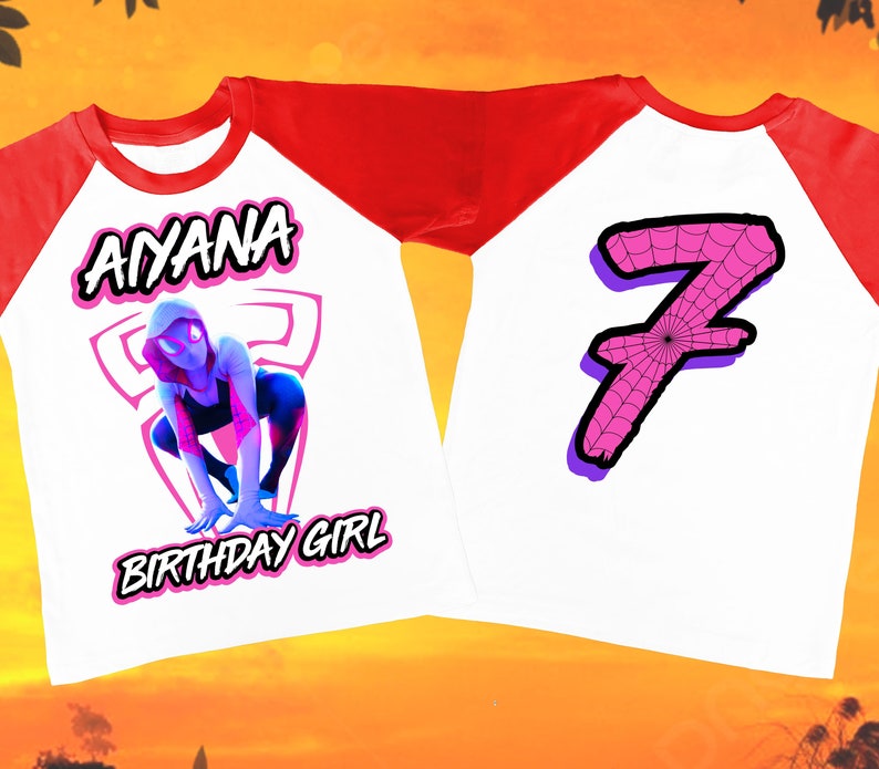 Puede incluir: Una camiseta de b&eacute;isbol blanca y roja con un gr&aacute;fico de una ara&ntilde;a rosa en la parte delantera y el nombre "AYANA BIRTHDAY GIRL" impreso debajo. La parte posterior de la camiseta tiene un n&uacute;mero 7 rosa con un dise&ntilde;o de telara&ntilde;a.