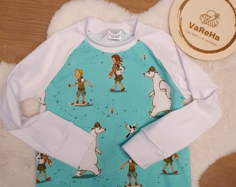 Sweaters in various sizes with a School of Magical Animals pattern in mint and white