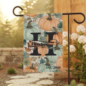 May include: A fall-themed garden flag with a large letter "H" and the text "Henderson est. 2008". The flag features a pattern of green and orange pumpkins.