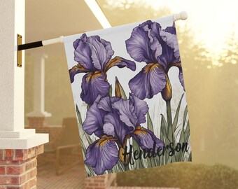 May include: A white garden flag with a purple and yellow iris flower design. The flag has the text "Henderson" printed on it.