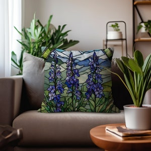 May include: A decorative throw pillow with a stained glass design featuring purple flowers and a mountain landscape.