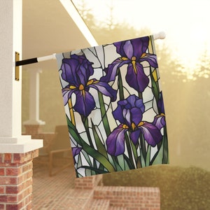 May include: A stained glass style garden flag featuring purple irises with yellow centers. The flag is white with green stems and leaves.