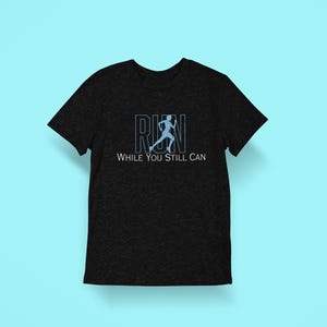 Könnte beinhalten: Schwarzes T-Shirt mit einer blauen Silhouette eines Läufers und dem Text "RUN WHILE YOU STILL CAN".