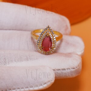 Anel em prata de lei 925 com rubi rosa em formato de pera e halo.