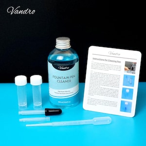 May include: A fountain pen cleaning kit with a blue liquid cleaner in a 5.8 fl oz bottle, two small vials, droppers, and an instruction card. The bottle and card have the brand name "Vandro". The cleaner is labeled "Fountain Pen Cleaner".